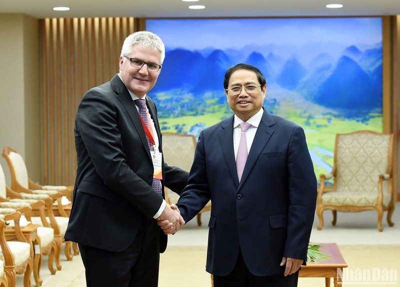 El primer ministro Pham Minh Chinh saluda al director de la Oficina Federal de Agricultura de Suiza, Christian Hofer. 