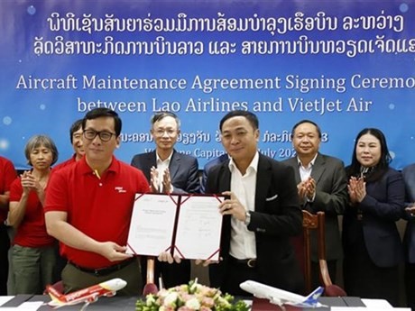 El director gerente de Lao Airlines Khamla Phommavanh (derecha) y el director ejecutivo de VietJet Air Dinh Viet Phuong muestran el acuerdo firmado. (Foto: VNA)