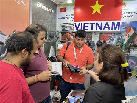 Visitantes visitan pabellones de calzado vietnamita en la feria. (Foto: VNA)