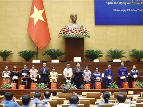 El presidente de la Asamblea Nacional, Vuong Dinh Hue, entrega obsequios a destacados miembros sindicales y trabajadores desfavorecidos. (Foto: VNA)