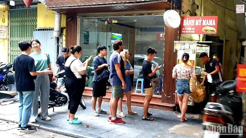 Turistas extranjeros hacen fila para comprar Banh Mi (bocadilllo vietnamita) en una tienda en la calle Ly Quoc Su, en Hanói.