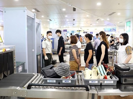 Empleados de seguridad en el aeropuerto realizan el proceso de control de seguridad. (Foto: Vietnam+)