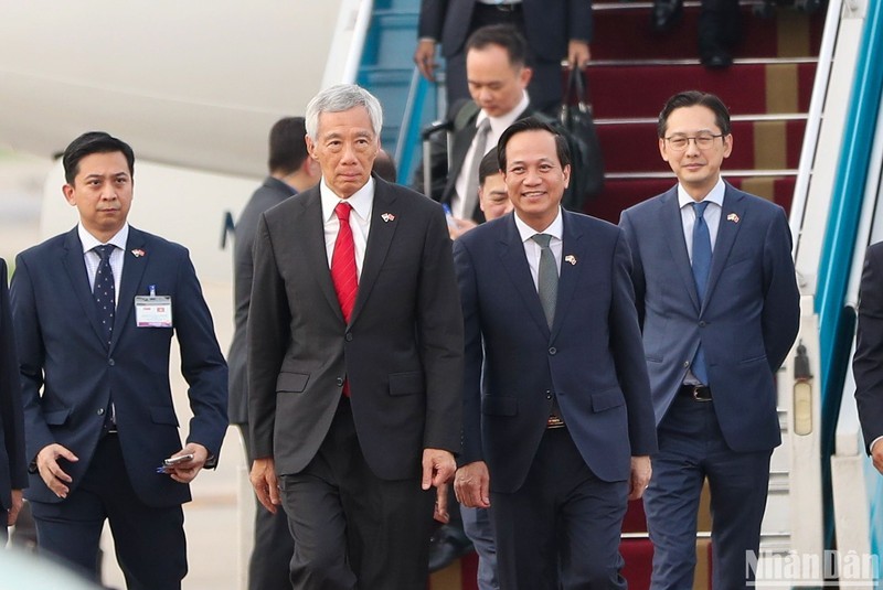  El ministro de Trabajo, Inválidos de Guerra y Asuntos Sociales, Dao Ngoc Dung, recibe al primer ministro de Singapur, Lee Hsien Loong, en el aeropuerto internacional de Noi Bai.