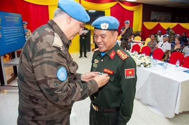 El subcomandante de la policía de la UNMISS, Murat Isik, presenta la medalla de mantenimiento de la paz de la ONU al primer coronel Le Quoc Huy. (Foto: VNA)