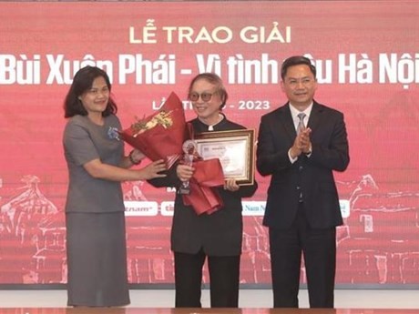 La subdirectora general de la VNA, Nguyen Thi Su, y vicepresidente del Comité Popular de Hanói, Ha Minh Hai entregan premio al director y artista del pueblo Dang Nhat Minh. (Foto: VNA)