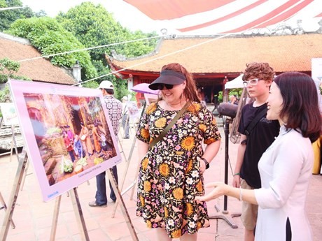 Turistas visitan la exposición fotográfica en el Templo de la Literatura. (Foto: hanoimoi.com.vn)