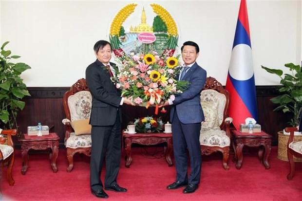 El embajador de Vietnam en Laos, Nguyen Ba Hung entrega flores para felicitar el 48º Día Nacional de la República Democrática Popular Lao. (Foto: VNA)