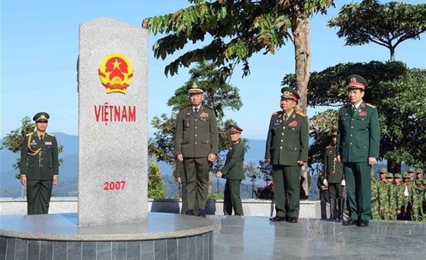 Los generales Phan Van Giang, Chansamone Chanyalath y Tea Seiha en el hito del cruce fronterizo entre Vietnam y Laos y Camboya. (Foto: VNA)