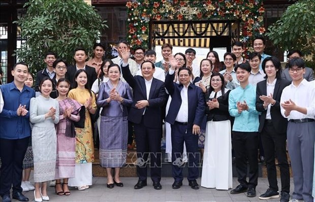 El primer ministro vietnamita, Pham Minh Chinh, su par laosiano, Sonexay Siphandone, sus esposas y estudiantes de ambos países. (Foto: VNA)