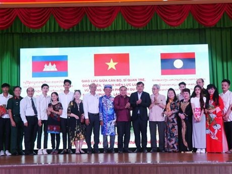 Representantes del Consulados Generales de Laos y de Camboya en Ciudad Ho Chi Minh se toman fotografías de recuerdo con estudiantes connacionales. (Foto: VNA)