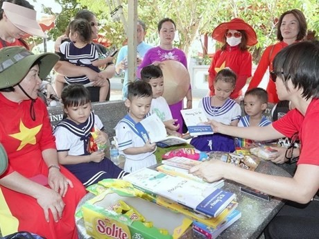 Una delegación de vietnamitas residentes en el extranjero entrega libros y regalos a los niños de Truong Sa. (Foto: VNA)