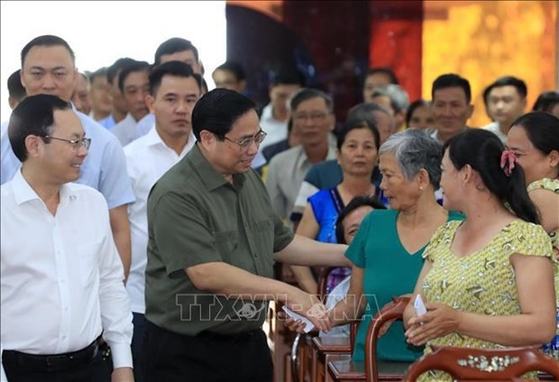 El primer ministro de Vietnam, Pham Minh Chinh, saluda a las familias beneficiarias de políticas sociales y personas que viven en circunstancias desfavorables. (Foto: VNA)