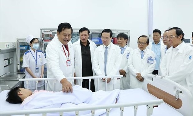 El presidente Vo Van Thuong (cuarta persona desde la izquierda) visita a un paciente que recibe tratamiento en el Hospital de Pediatría 1 de Ciudad Ho Chi Minh. (Fotografía: VNA)