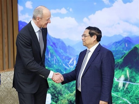 El primer ministro vietnamita, Pham Minh Chinh (derecha), recibe a Roland Busch, presidente y director ejecutivo de Siemens. (Foto: VNA)