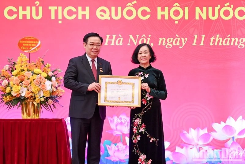 La miembro del Buró Político y permanente del Secretariado del Comité Central del PCV y jefa de su Comisión de Organización, Truong Thi Mai, entrega la insignia a Vuong Dinh Hue. 