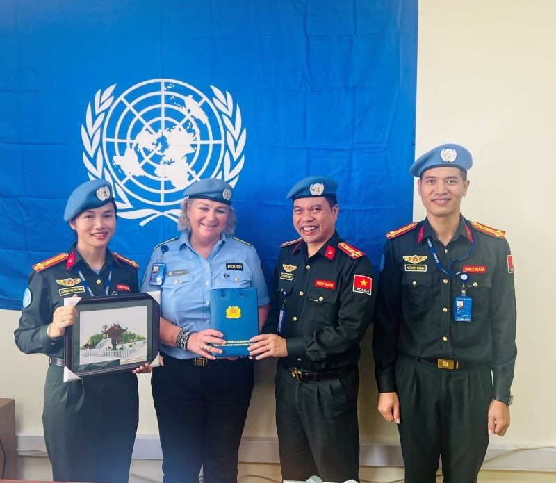 La comisionada de Policía de la Misión de las Naciones Unidas en Sudán del Sur (Unmiss), Christine Fossen, otorga certificados de mérito a tres oficiales de la Fuerza de Seguridad Popular de Vietnam.