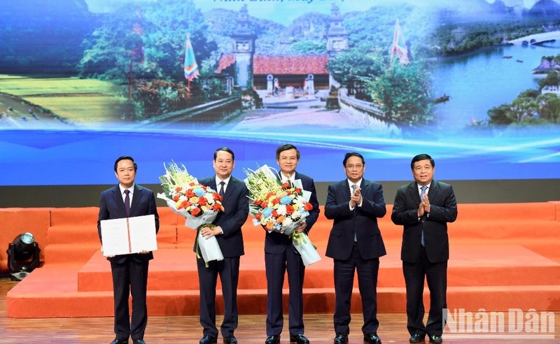 El primer ministro Pham Minh Chinh y el ministro de Planificación e Inversiones Nguyen Chi Dung entregan la decisión que aprueba la planificación de Ninh Binh a los dirigentes de la provincia.