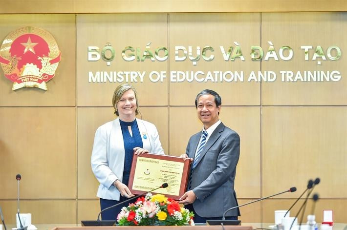 El ministro de Educación y Formación de Vietnam, Nguyen Kim Son, entrega el sello conmemorativo "Por la Causa de la Educación" a la representante de Unicef en Vietnam, Rana Flowers. (Foto: thoidai.com.vn) 