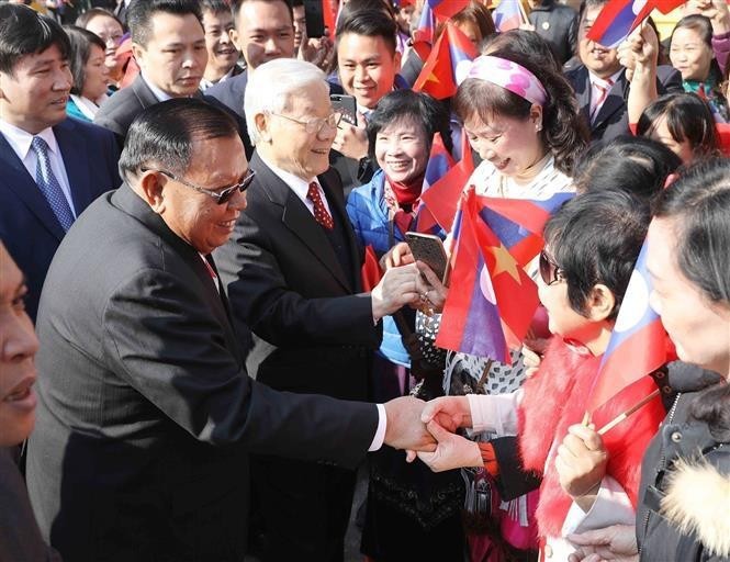 El secretario general del PCV, Nguyen Phu Trong, y el secretario general del PRPL y presidente de Laos, Bounnhang Vorachith, con el pueblo de Hanói en la mañana del 19 de diciembre de 2017. (Foto: VNA)