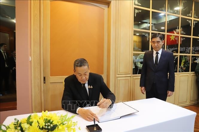 El primer ministro tailandés, Srettha Thavisin, escribe en el libro de condolencias. (Foto: VNA)