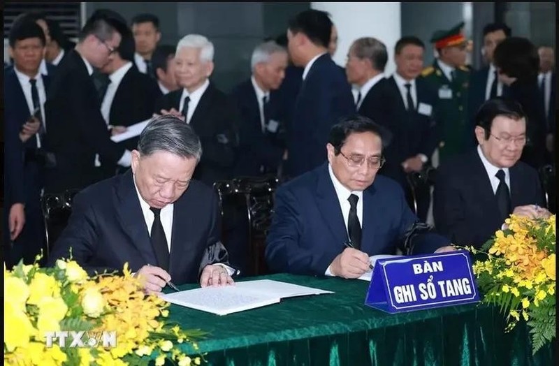 El miembro del Buró Político y presidente del Estado, To Lam (izquierda), y el miembro del Buró Político y primer ministro, Pham Minh Chinh (centro), escriben en el libro de condolencias. (Foto: VNA)