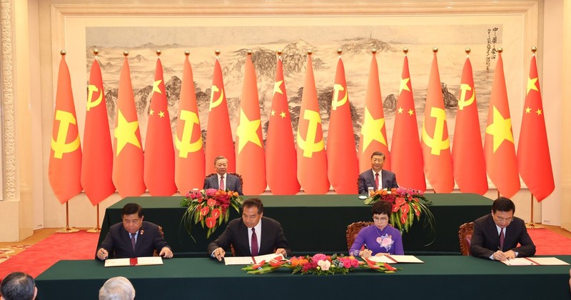 Ceremonia de firma del Acuerdo de Cooperación entre la Agencia Vietnamita de Noticias y la Agencia de Noticias Xinhua (derecha) y la cooperación en materia de inversiones (izquierda) entre los dos países. (Foto: VNA)