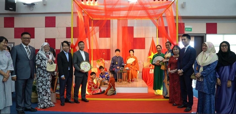 Los delegados toman fotos con modelos vietnamitas en el Ao dai. 