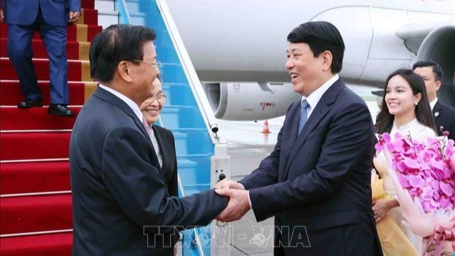 Luong Cuong, miembro del Buró Político y permanente del Secretariado del PCV, da la bienvenida al máximo dirigente laosiano, Thongloun Sisoulith, y a su esposa, en el aeropuerto internacional de Noi Bai. (Foto: VNA)