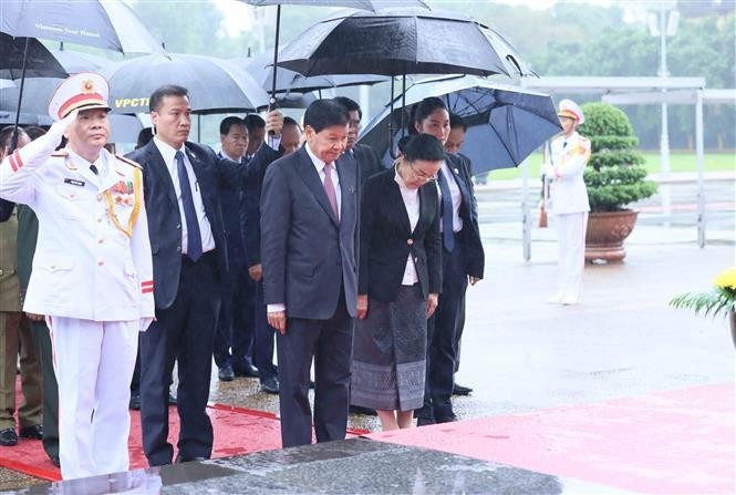 El secretario general del Partido Popular Revolucionario y presidente de Laos, Thongloun Sisoulith, su esposa y la delegación laosiana de alto rango rinden tributo al Presidente Ho Chi Minh. (Foto: VNA)