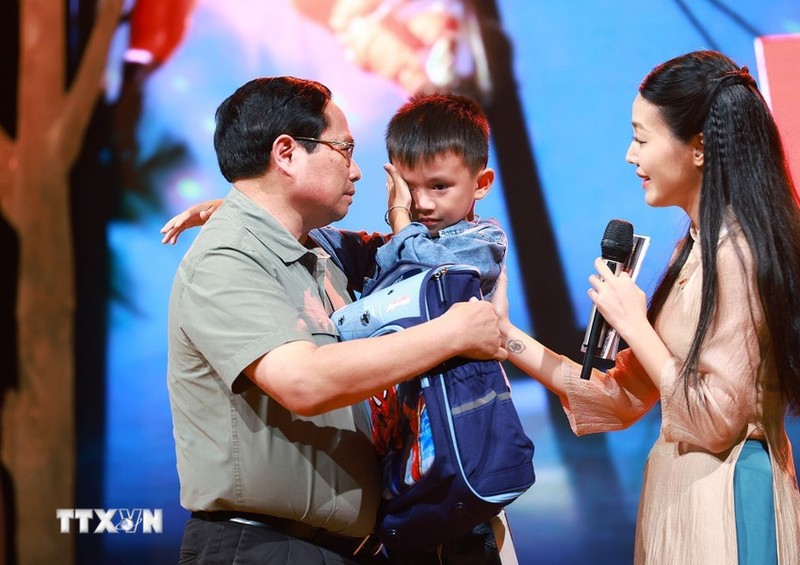 El primer ministro Pham Minh Chinh alentó a Nguyen Quoc Bao, quien perdió a su padre y su hermana mayor por las inundaciones en la comuna de Yen Thuan, distrito de Ham Yen, provincia de Tuyen. Quang. (Foto: VNA)