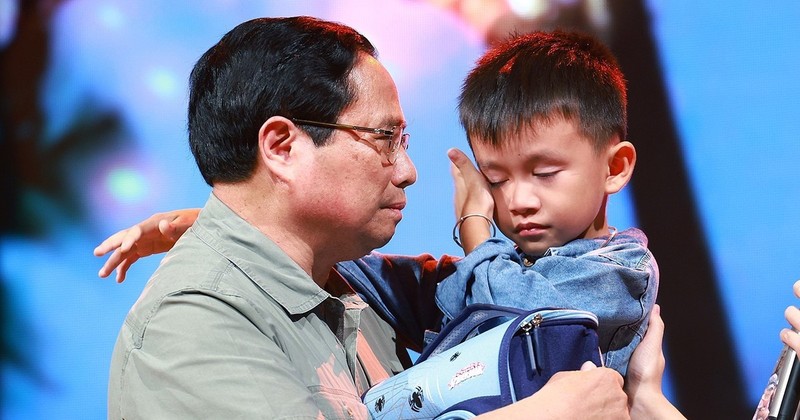 El primer ministro entrega obsequio a un niño cuyos familiares fallecieron por el tifón Yagi. (Foto: VNA)