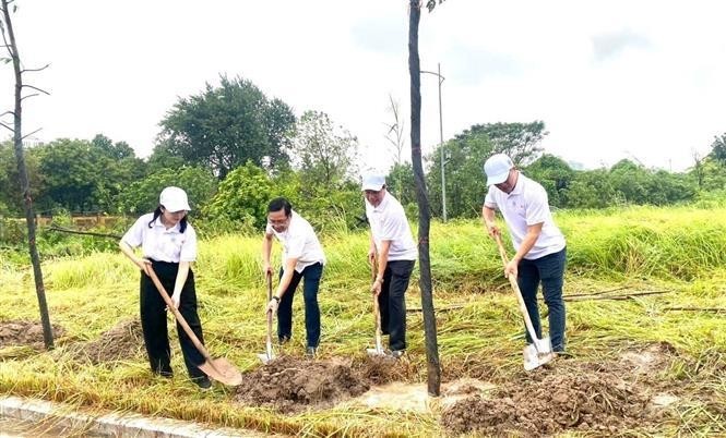 Los delegados participan en la plantación de árboles luego de la ceremonia. (Foto: VNA)