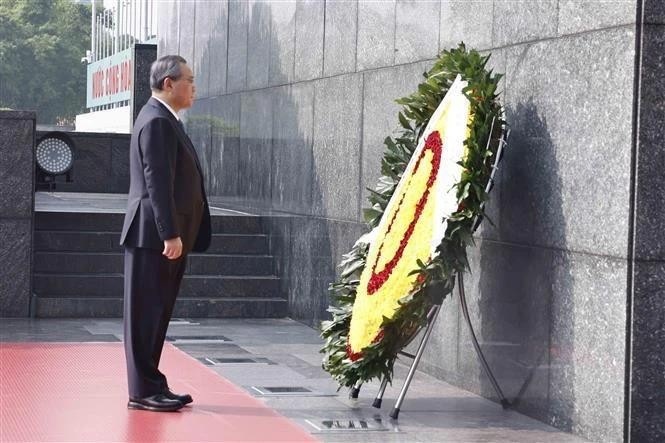 El primer ministro chino Li Qiang rinde homenaje al Presidente Ho Chi Minh en el mausoleo dedicado al prócer de la independencia de Vietnam. (Foto: VNA)