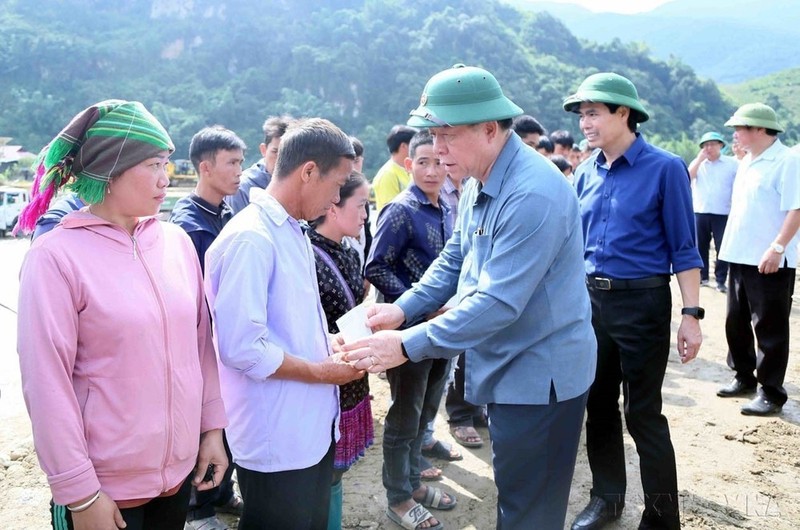 Nguyen Trong Nghia, miembro del Buró Político, secretario del Comité Central del Partido Comunista de Vietnam, entrega obsequios a las personas de la comuna de Ngoc Chien, distrito de Muong La, provincia de Son La, afectadas por el tifón Yagi. (Foto: VNA)