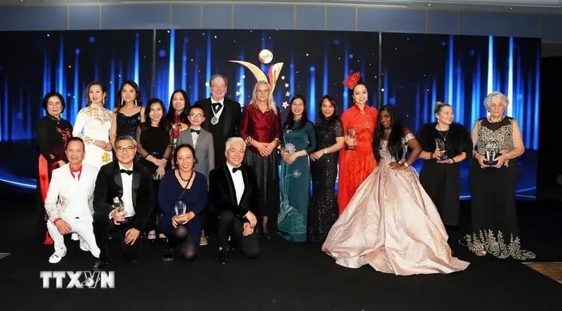 La embajadora adjunta de Vietnam en el Reino Unido, To Minh Thu (con un Ao Dai verde), se toma una foto con los ganadores. (Foto: VNA)