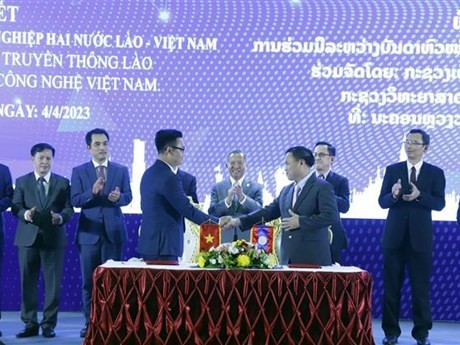 Acto de firma de acuerdos de cooperación entre socios vietnamitas y laosianos en el marco del Foro (Foto: VNA)