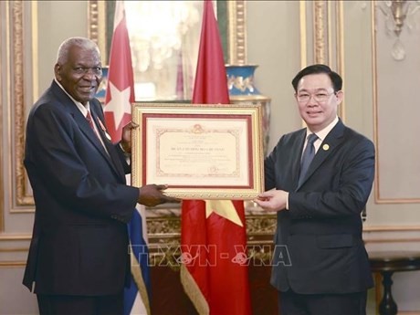 Presidente parlamentario Vuong Dinh Hue entrega el título de reconocimiento a Esteban Lazo Hernández (Foto: VNA)