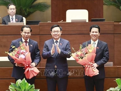 El presidente de la Asamblea Nacional, Vuong Dinh Hue, felicitó al nuevo jefe de la Comisión de Finanzas y Presupuesto del Parlamento de la XV legislatura, Le Quang Manh (izquierda) y al nuevo ministro de Recursos Naturales y Medio Ambiente, Dang Quoc Khanh (derecha), mandato 2021 -2026. (Fuente:VNA)