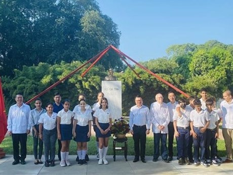 El editor jefe del diario Nhan Dan, Le Quoc Minh, y la delegación que le acompaña, colocan ofrendas florales ante el busto del Presidente Ho Chi Minh en el parque que lleva su nombre en La Habana. (Foto: VNA)