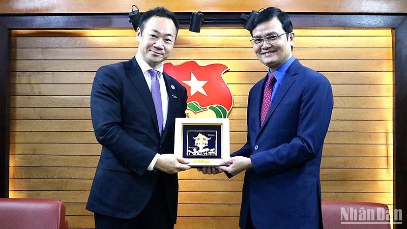 El primer secretario de la Unión de Jóvenes Comunistas Ho Chi Minh (UJC), Bui Quang Huy, entrega un regalo al subjefe de la División de Investigación de Políticas de Japón, Suzuki Keisuke. 