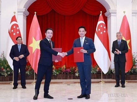 El primer ministro Pham Minh Chinh y su homólogo singapurense Lee Hsien Loong, presencian la ceremonia de firma de documentos de cooperación entre los dos países en Singapur el 9 de febrero de 2023. (Fuente: VNA)