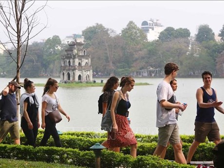 Turistas extranjeros en el lago Hoan Kiem, Hanoi (Foto: VNA)