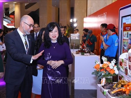 La ministra vietnamita de Salud, Dao Hong Lan, y el embajador canadiense Shawn Steil visitan los pabellones de exposición en la cita (Foto: VNA)