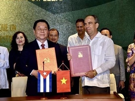 Nguyen Trong Nghia y Rogelio Polanco Fuentes firman un acuerdo de cooperación entre sus respectivos órganos (Fuente: VNA)