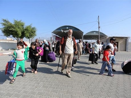 Las personas salen de la Franja de Gaza a través del paso fronterizo de Rafah hacia Egipto. (Fuente: Xinhua/VNA)