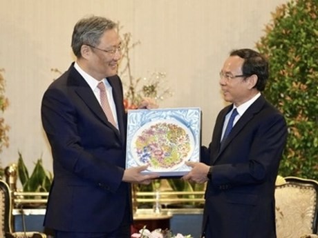 Wang Wentao regala a Nguyen Van Nen un cuadro cerámico que simboliza la amistad de los dos países, con las flores nacionales de los dos países, la peonía y el loto (Fuente: VNA)