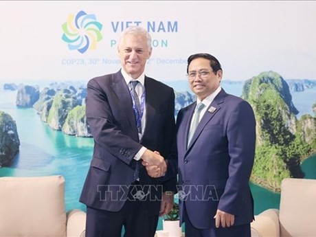 El primer ministro Pham Minh Chinh (derecha) y el director ejecutivo del grupo Standard Chartered Bill Winters. (Foto: VNA)
