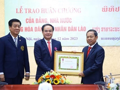 El vicepresidente del Comité Central del Frente Laosiano de Construcción Nacional Khamlay Sipraseuth entrega la Orden Itxala de tercera categoría al viceministro del Interior Vu Chien Thang. (Fuente: VNA)