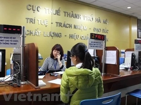Las personas realizan trámites en el Departamento de Impuestos de Hanói. (Fuente:VNA)