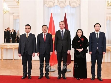 El presidente de Letonia, Edgars Rinkevics, junto con los diplomáticos de la Embajada vietnamita (Foto: VNA) 